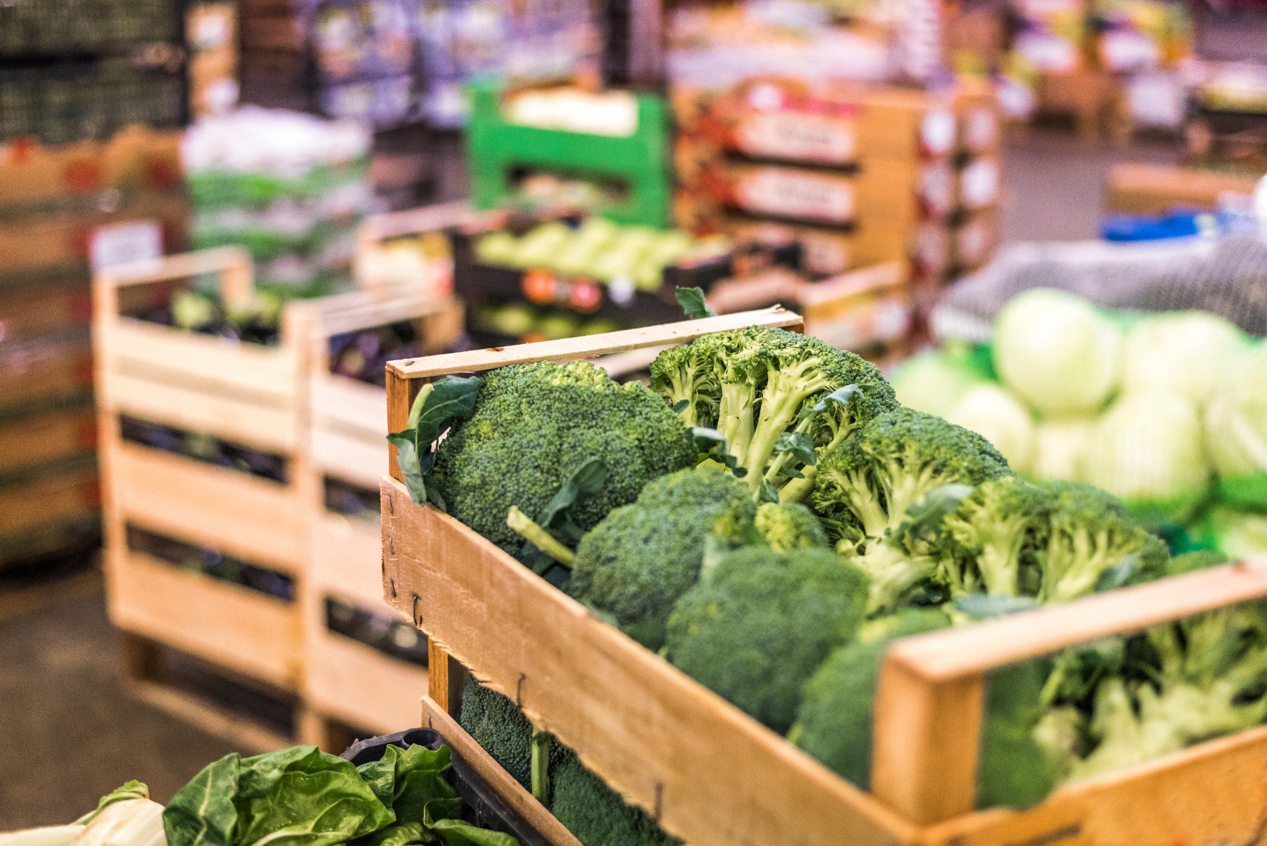 Świeże brokuły w drewnianych skrzynkach na targu, symbolizujące dbałość Marketu Świeżości DPD o lokalne i świeże produkty.